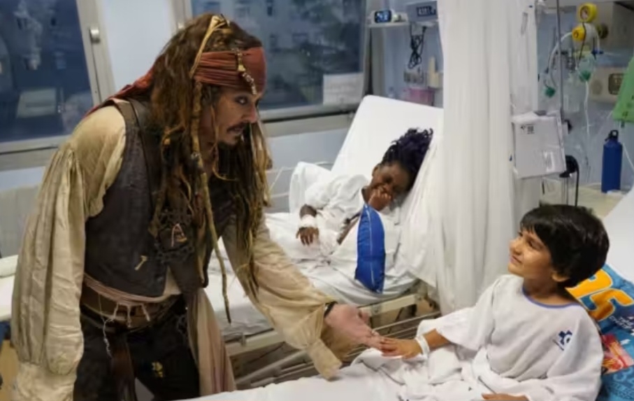 Ele conversou e brincou com a garotada que se trata de câncer na ala reservada para pediatria oncológica. Depp costuma fazer esse tipo de visita, para levar alegria a pessoas que passam por um difícil tratamento.  Reprodução: Flipar