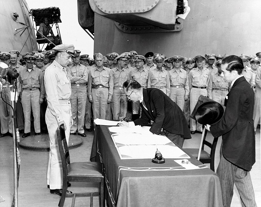 A rendição oficial foi em 14/9. Na foto, o Ministro das Relações Exteriores do Japão Mamoru Shigemitsu assina a Ata de rendição do país no USS Missouri sendo visto por Richard K. Sutherland, oficial do Exército dos EUA.