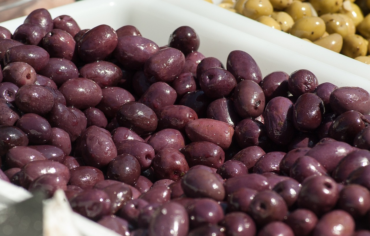 Antes de irem para o consumo, elas são verdes. Ocorre que, para se tornarem pretas, elas passam por um processo de maturação. Essas azeitonas são colhidas quando estão maduras e têm uma cor roxa-escura ou preta.  Reprodução: Flipar