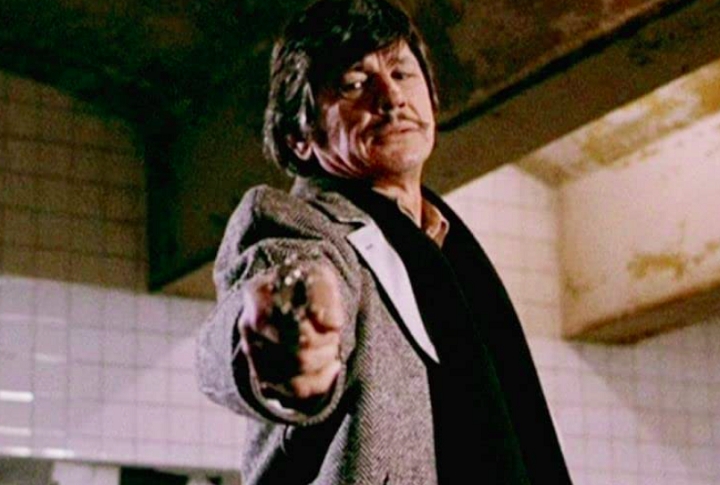 O filme contava a história de um homem comum, arquiteto da cidade de Nova Iorque, que tem sua mulher morta e sua filha abusada por três bandidos, o que faz com que o personagem de Bronson comece a agir como um “vigilante do crime”. Reprodução: Flipar