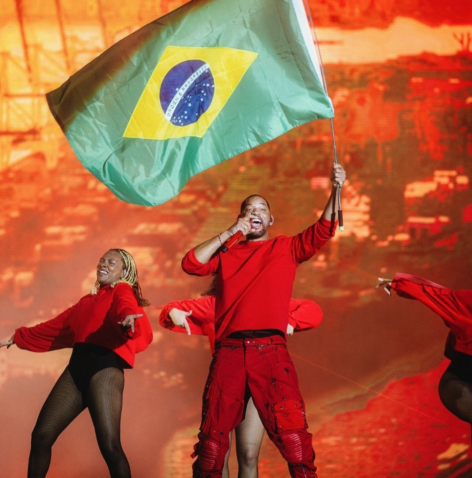 Acompanhado de jovens dançarinas, ele exibiu uma bandeira do Brasil em um momento do show e disse, em português, que se sentia feliz em estar no país. Ele dividiu o palco numa das músicas com o coral Cariocanto.  Reprodução: Flipar