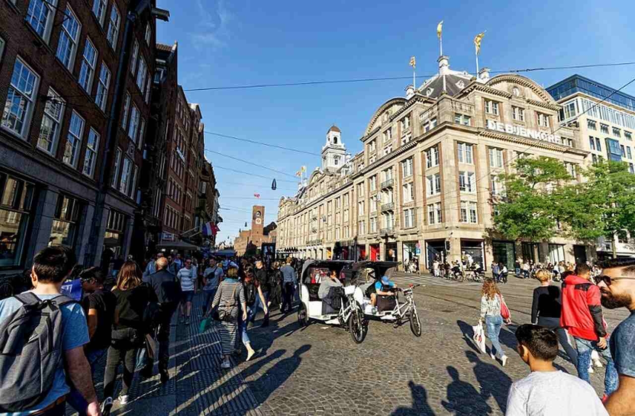 Praça Dam (Dam Square) - Descrição: Esta é a praça central de Amsterdã, estabelecida no século XIII, onde a cidade começou a se desenvolver - Abriga o Palácio Real, a Nova Igreja (Nieuwe Kerk) e o Monumento Nacional - Localização: Centro de Amsterdã - Referências Históricas: A praça foi o ponto de encontro para muitos eventos históricos, incluindo protestos e celebrações Reprodução: Flipar