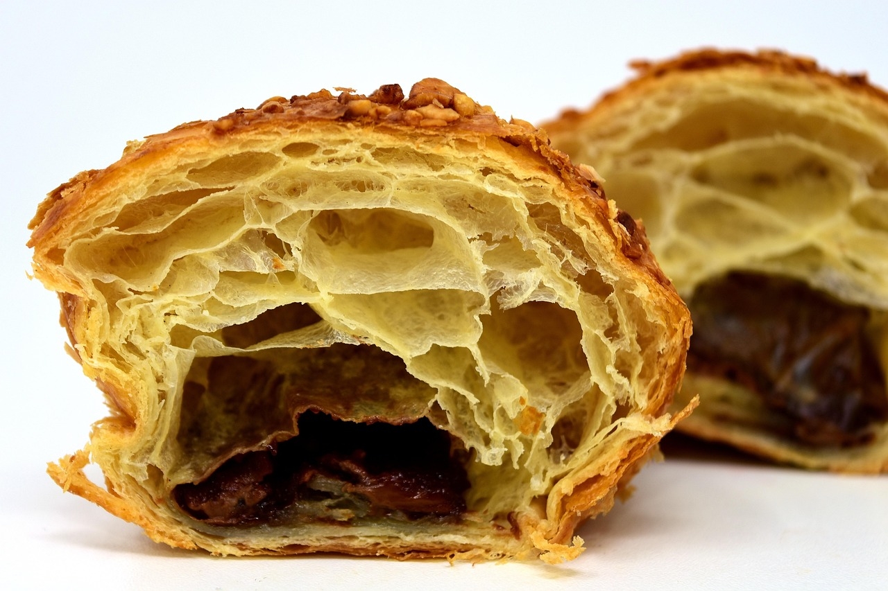 Nas primeiras, a massa era mais densa e pesada e se parecia com um pão comum. Apenas em 1900, um padeiro francês decidiu mudar e deixar a massa folhada e, por consequência, mais leve.  Reprodução: Flipar
