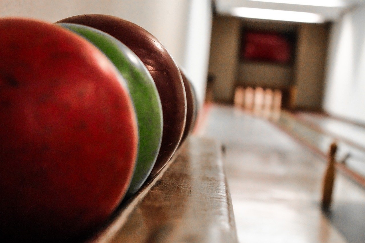 Insira dedos polegar, médio e anelar nos furos, segure a bola com as 2 mãos e concentre-se na hora de jogar. Assim, segure a bola na altura do peito (braço em L) e caminhe naturalmente para jogar, sem pressa.
 Reprodução: Flipar