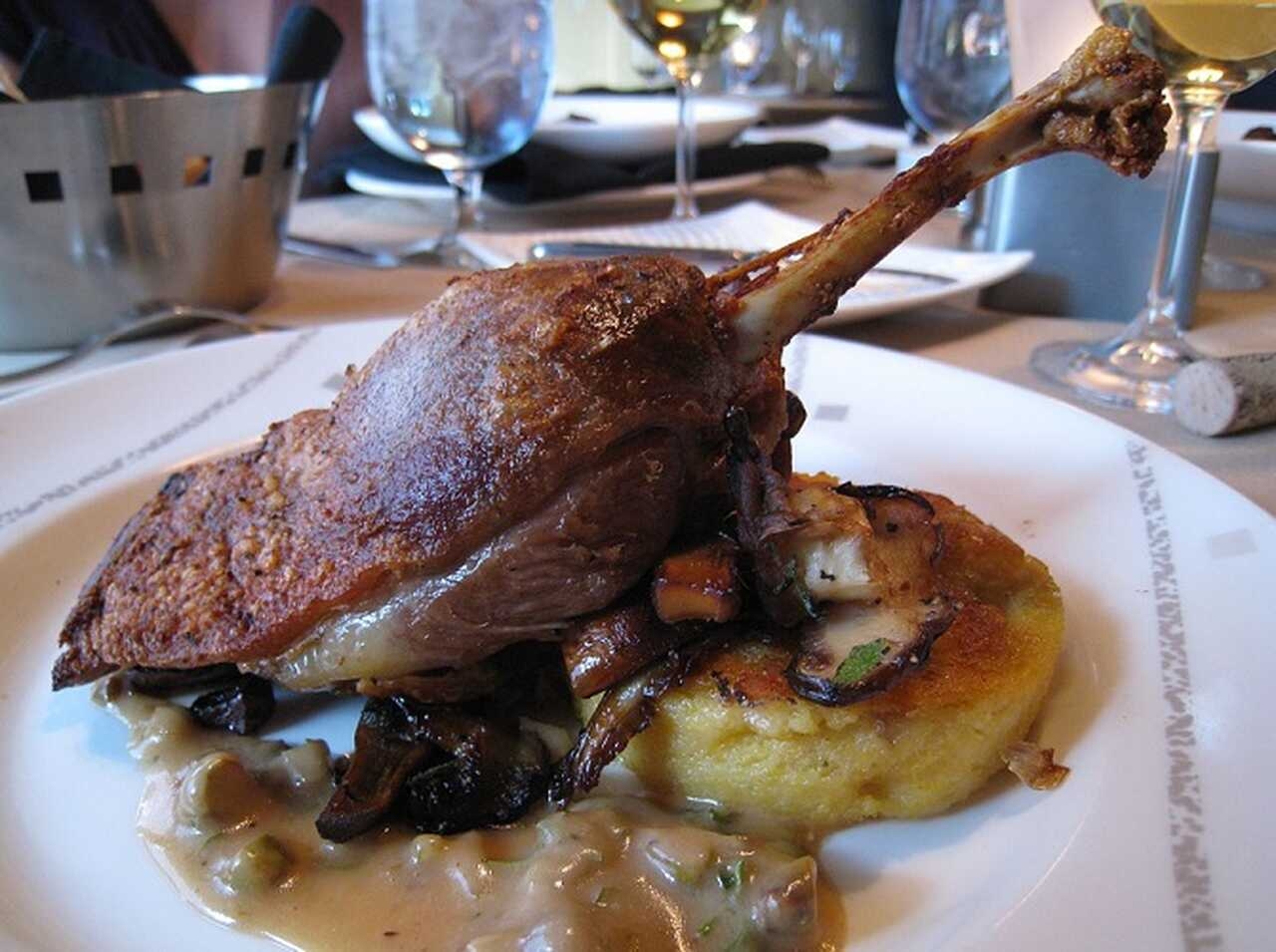 Confit de Pato - Coxa de pato cozida lentamente em sua própria gordura até ficar macia e suculenta, servida com batatas ou lentilhas Reprodução: Flipar