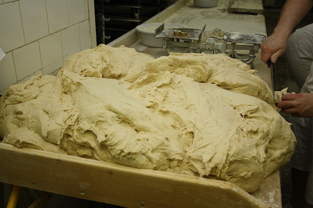 Nas padarias, uma grande massa é preparada e os pãezinhos são cortados para irem ao forno.  Reprodução: Flipar
