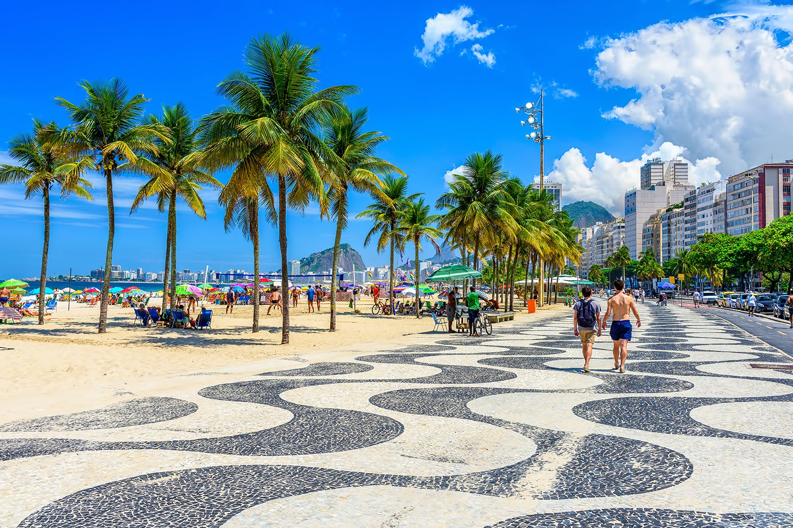 Um clássico do Rio de Janeiro, Copacabana atrai visitantes com sua famosa calçada, areias douradas e vibrante vida noturna. Reprodução/Wowtickets.com