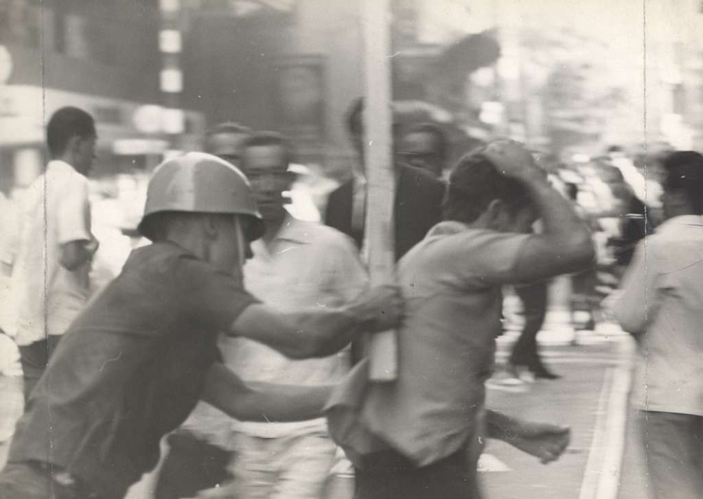 Homem sendo agredito por militares durante manifestação contra a ditadura Reprodução: commons