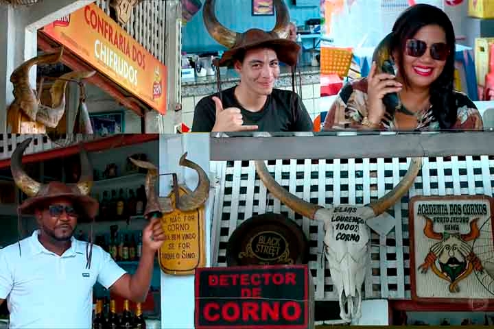 Em alguns lugares, prevalece apenas a descontração em torno do tema. Em Recife, dentro do Mercado da Madelena, há um bar chamado “Confraria dos Cornos”. O ambiente é adornado com peças que remetem ao folclore em torno da figura do traído, como chifres e frases talhadas em madeira.  Reprodução: Flipar