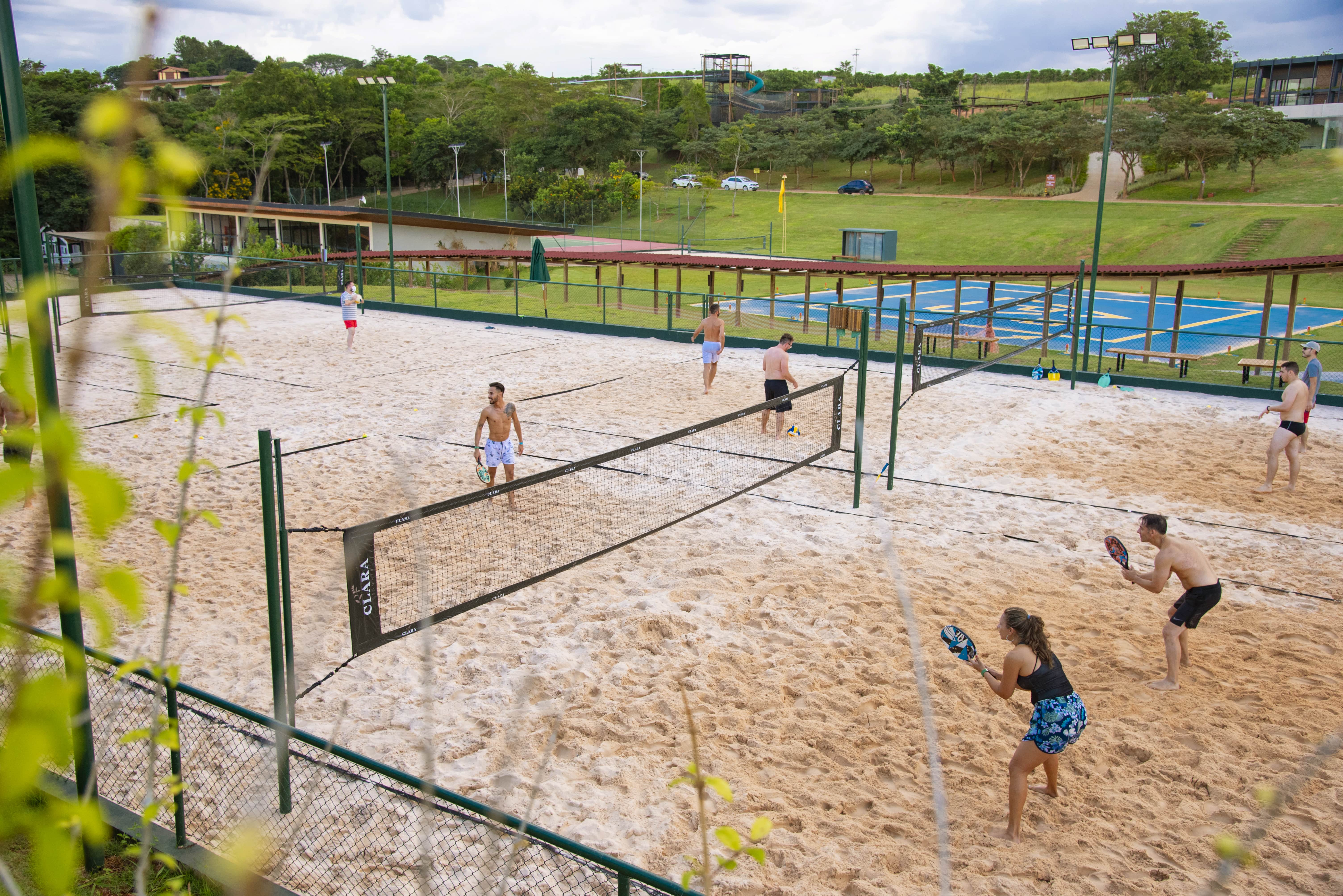 Quadra de beach tennis do Piscina do Clara Ibiúna Resort; heliponto ao fundo. Foto: Clara Ibiúna Resort/Divulgação