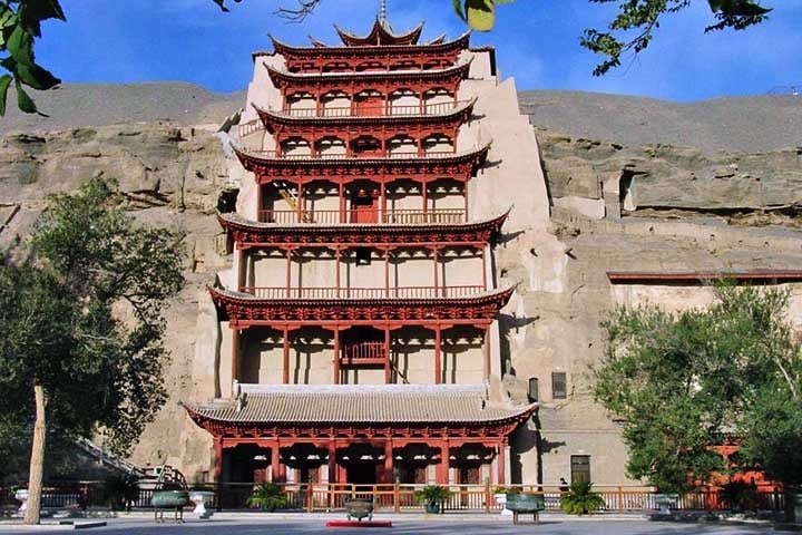 Situadas na margem do deserto, as cavernas de Mogao, esculpidas nas encostas arenosas, preservam antigos santuários, esculturas e murais datados do século 4.  Reprodução: Flipar