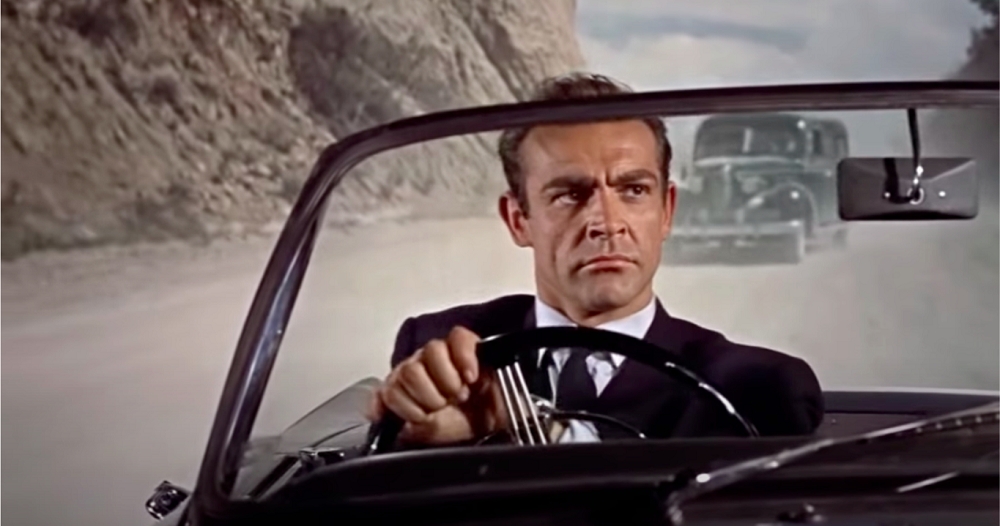 Som errado em “007 Contra o Satânico Dr. No” (1962): Em uma cena de perseguição, Bond está fugindo de carro e é possível ouvir sons de pneus “cantando” na cena. Acontece que a fuga acontece em um chão de terra e não em asfalto… Reprodução: Flipar