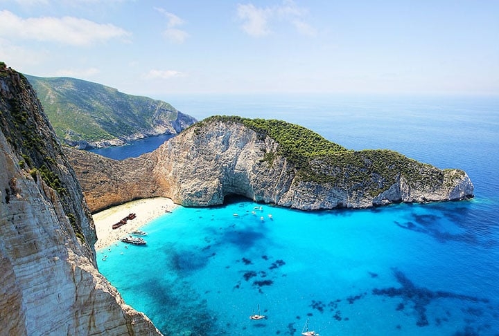 Com alturas imponentes, as falésias oferecem uma vista espetacular para o mar turquesa. A praia é conhecida por sua areia branca, águas cristalinas e os penhascos de calcário. Reprodução: Flipar